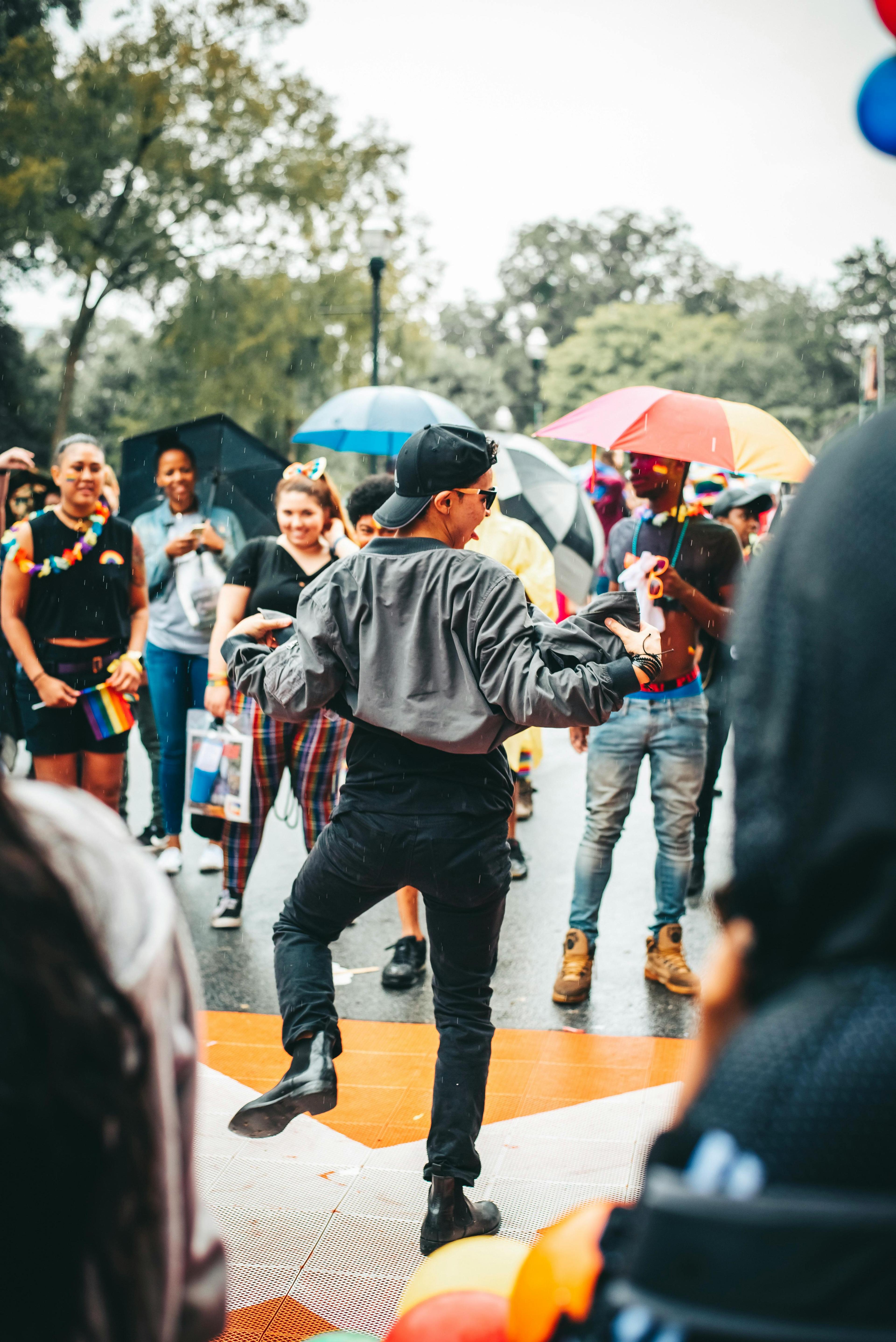 Festival goers dancing in the rain under a crowd of umbrellas